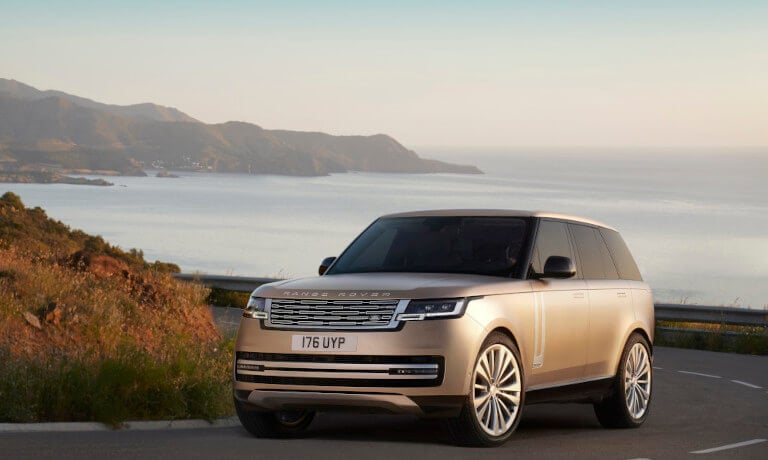 2022 Land Rover Range Rover Driving On A Curving Seaside Road At Sunrise