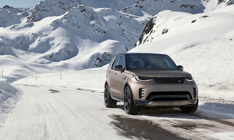 2026 Land Rover Discovery driving in snowy mountains