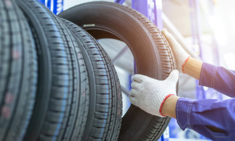 Technician Pulling Tires Off Of Shelf