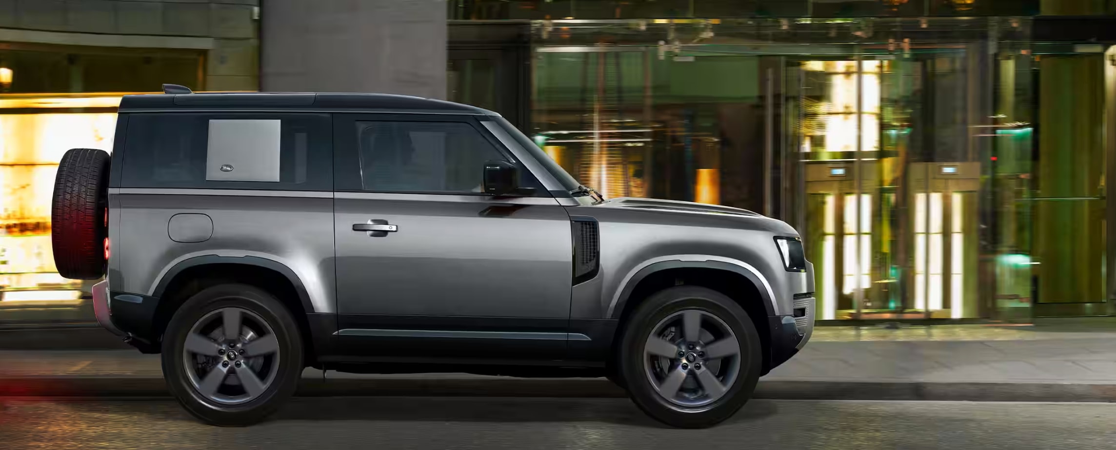 Side profile of the 2023 Defender on a city street