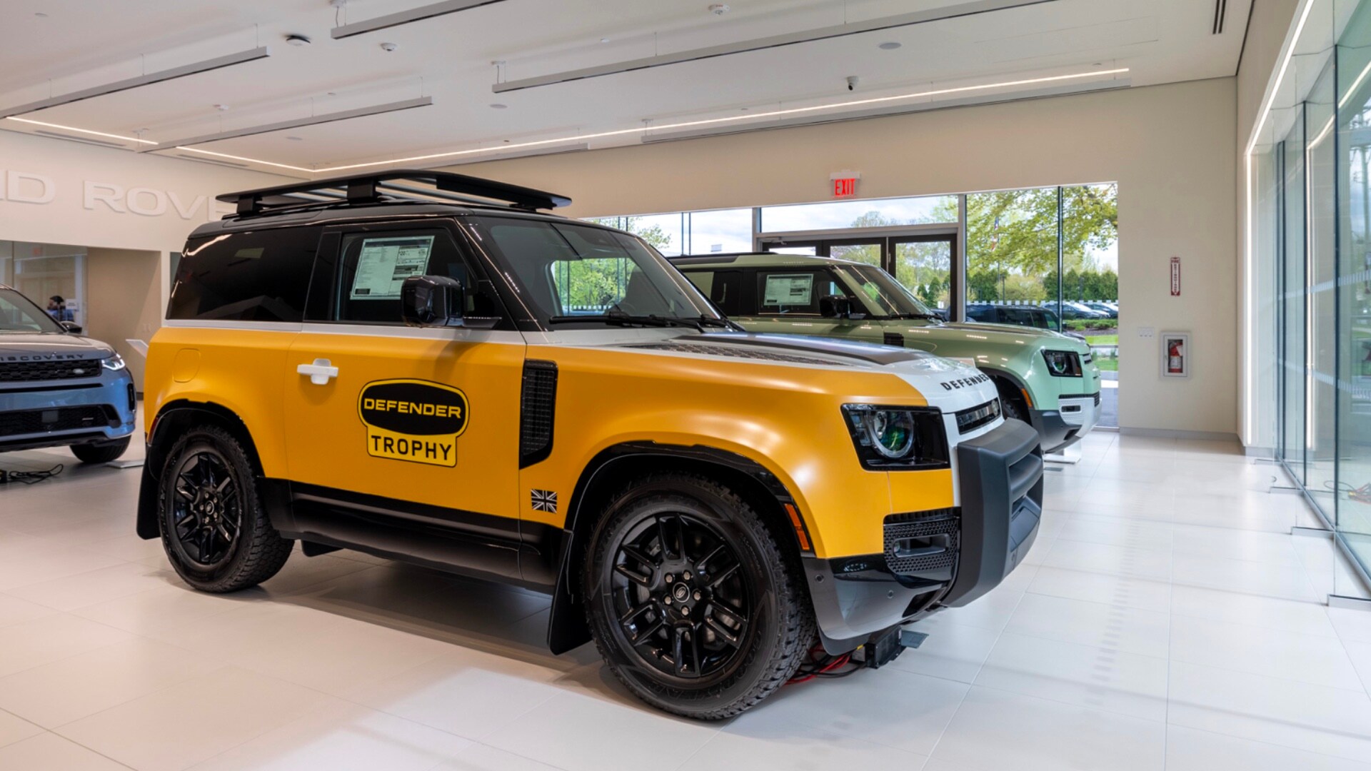 Land Rover Mt. Kisco Finance Center Interior of Land Rover Mt. Kisco. A yellow Land Rover Defender is seen displayed in the showroom along with several other vehicles.