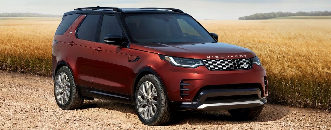 Red 2026 Land Rover Discovery parked near a wheat field