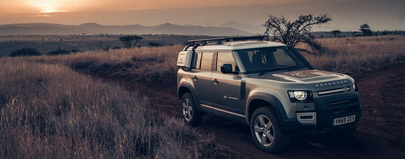 Grey 2026 Land Rover Defender driving off-road.