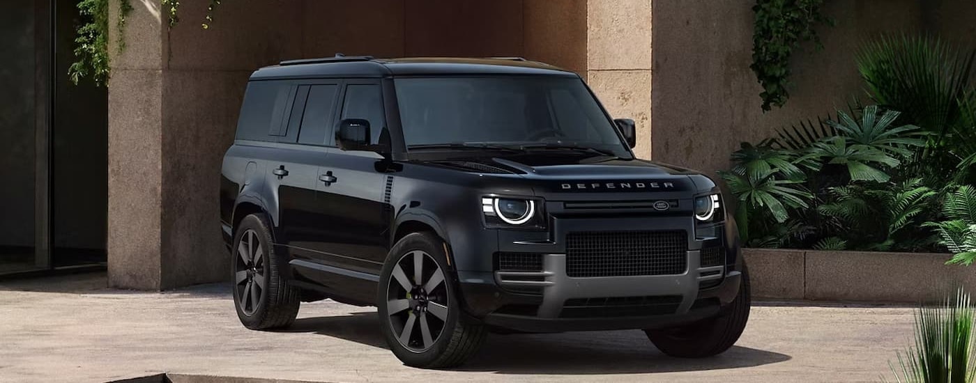 Black 2026 Land Rover Defender parked in front a building.