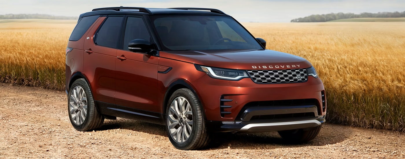 Red 2026 Land Rover Discovery parked off-road.