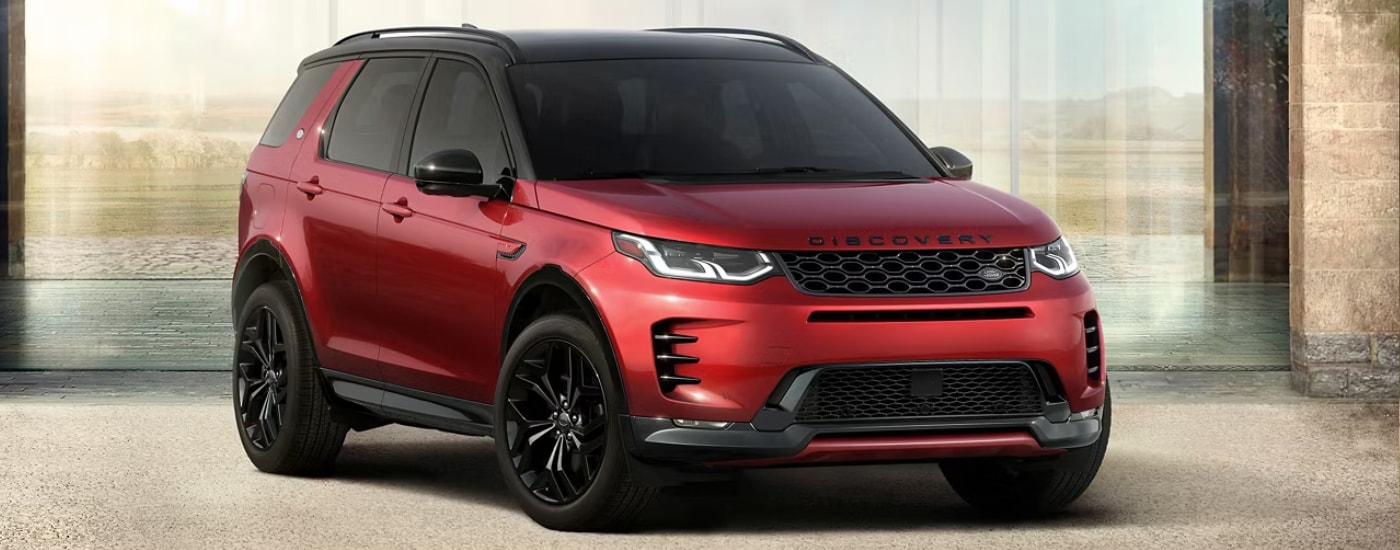 A red 2026 Land Rover Discovery Sport parked in a driveway
