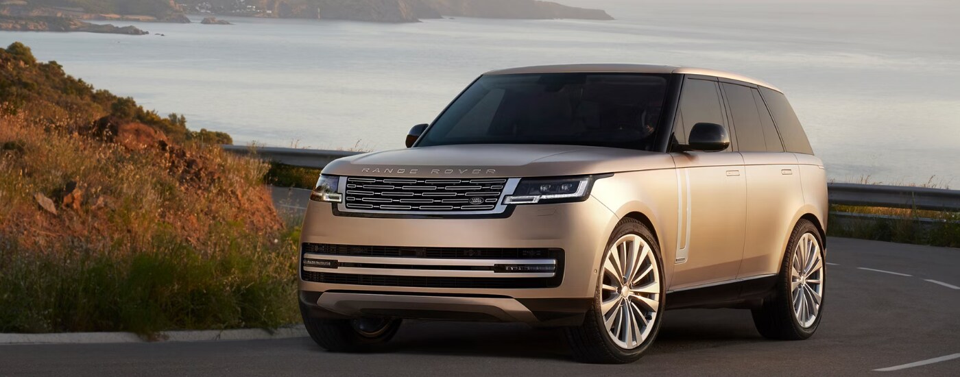 Beige 2026 Range Rover rounding a bend