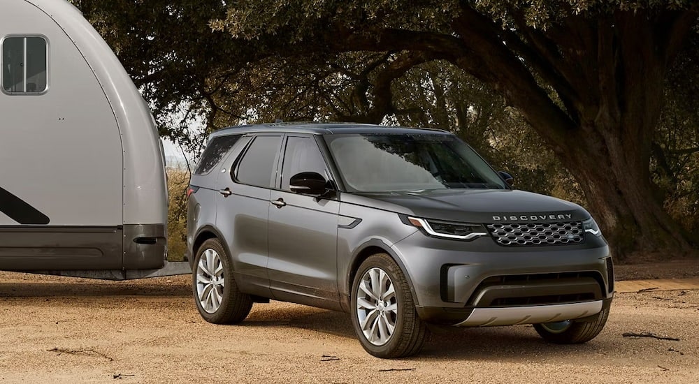 Grey 2026 Land Rover Discovery parked near a camper van.