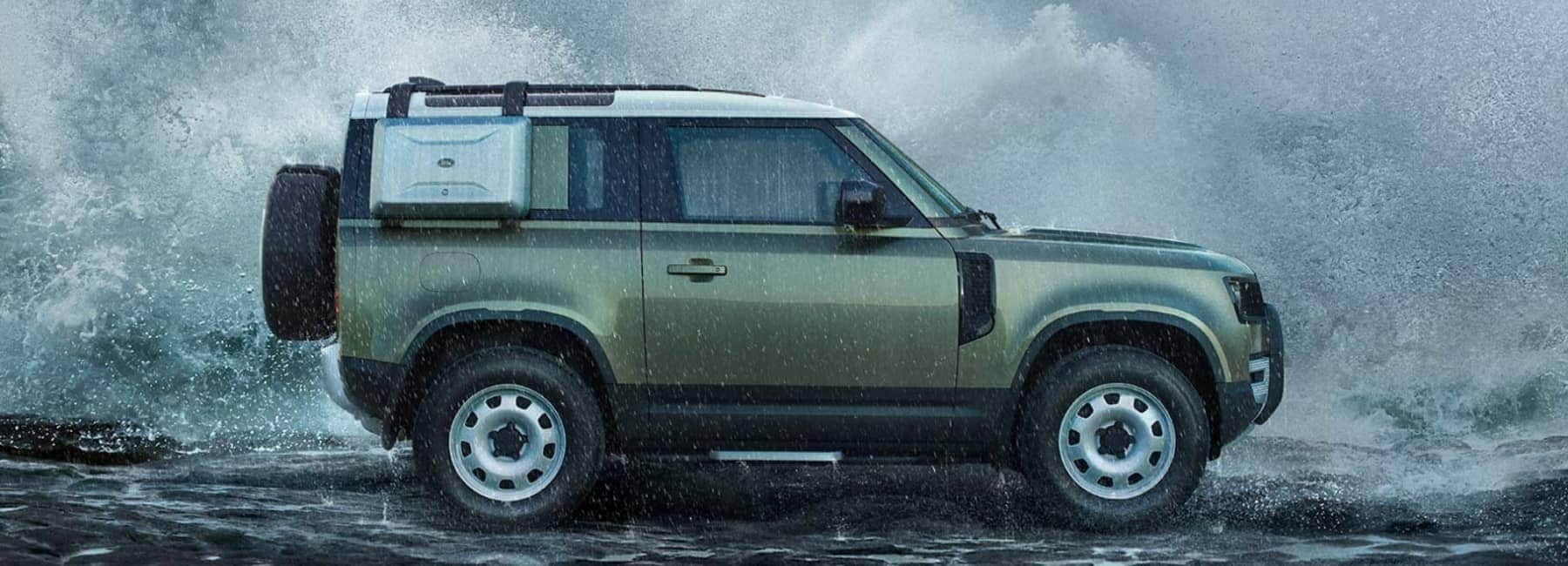 2022 landrover_defender-sideview-huge-wave-splash-behind-car-green