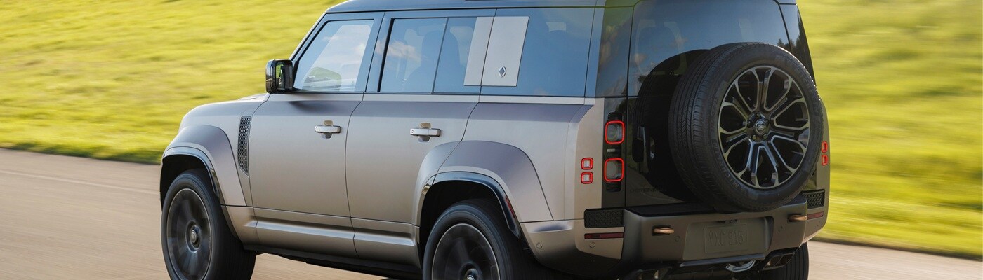 Defender 130 SUV driving away on a sunny day