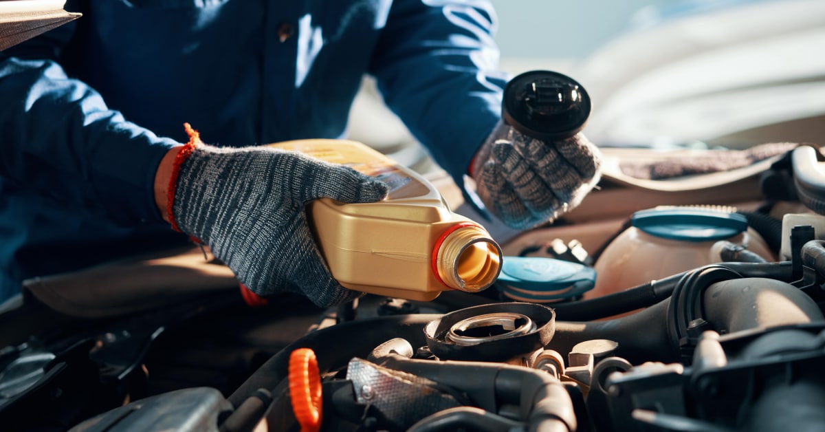 a%20car%20mechanic%20puring%20engine%20oil%20in%20a%20car.jpg
