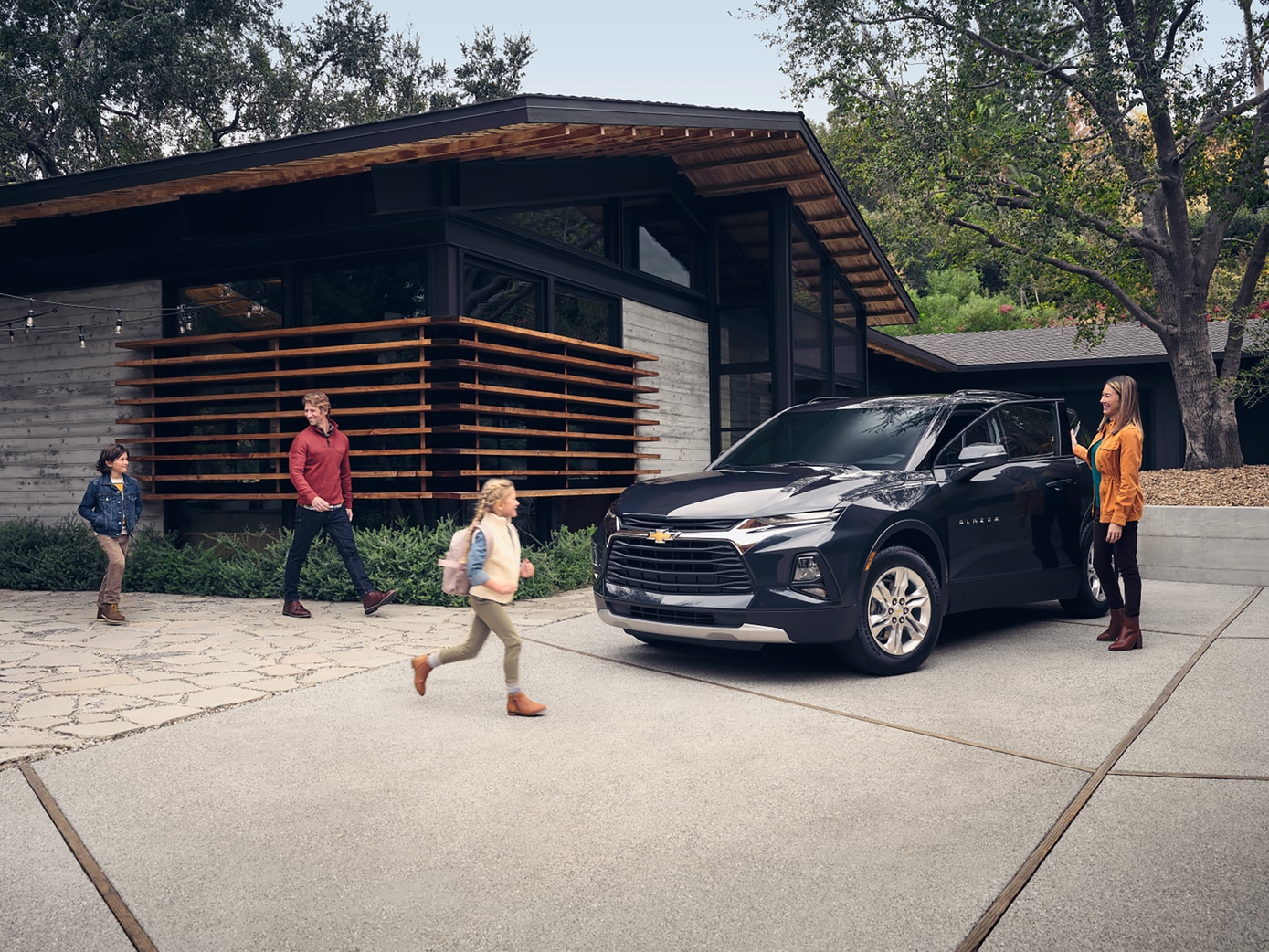  family walking towards Chevy Blazer parked outside home