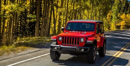 red jeep wrangler suv on the road
