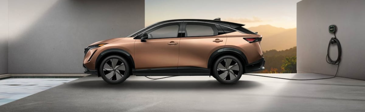 Nissan Ariya plugged into a wall mounted charger