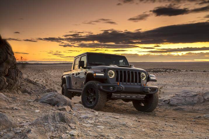 Vue 3/4 avant d'un Jeep Gladiator Mojave 2022 garé dans un désert au crépuscule