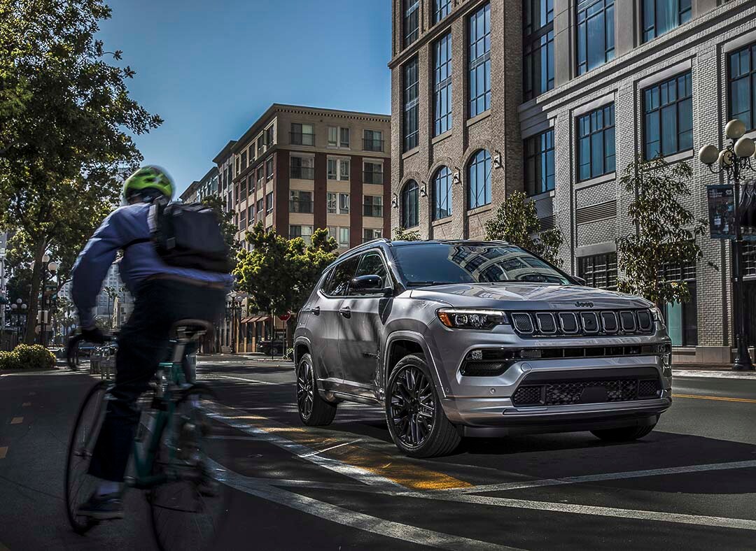 Cycliste circulant à côté du Jeep Compass High Altitude 2022 en ville