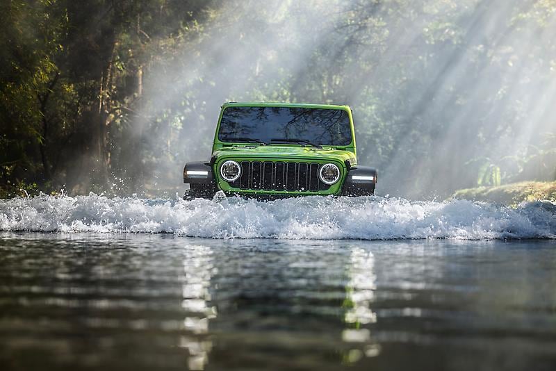 Green Jeep Water Fording on a stream deep in the forest
