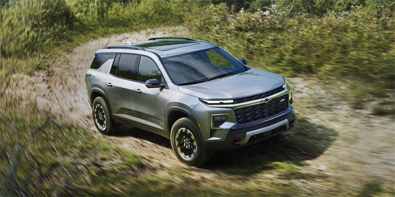 The 2026 Chevy Traverse displaying its power and performance in the outdoors as its driving on a dirt trail