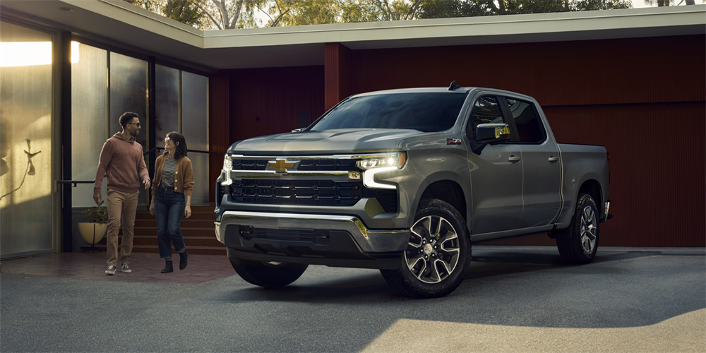 Couple Shown next to the 2026 Chevrolet Silverado 1500 Parked near home garage 