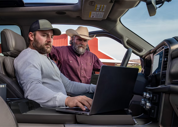 Working men discussing a job behind the wheel of a 2026 Ford F-150