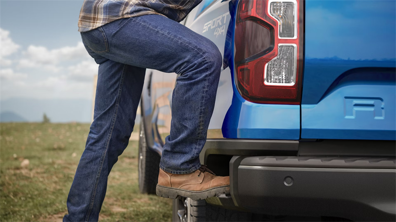 Man climbing the behind of a 2026 Ford Ranger truck bed