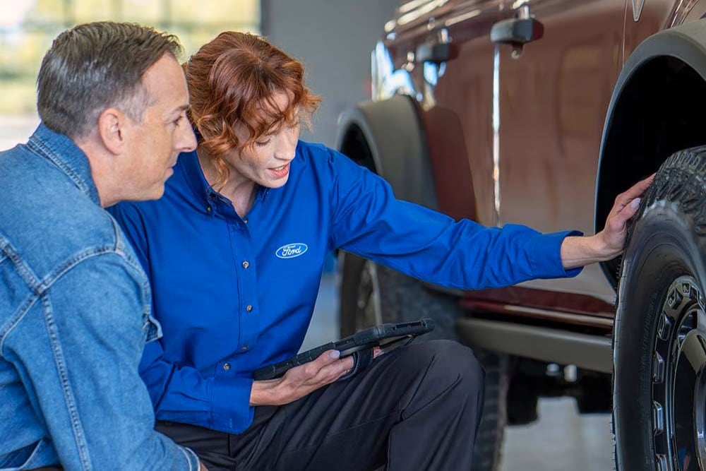 Ford Salesperson showing a customer a Ford Certified Pre-Owned Vehicle