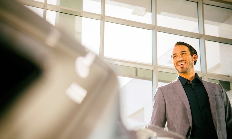 A man in a suit in a car dealership