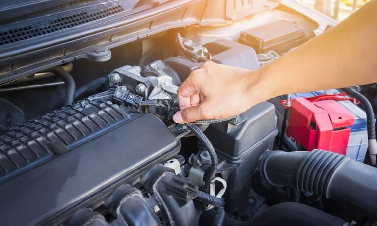 Mechanic unplugging engine sensor wires