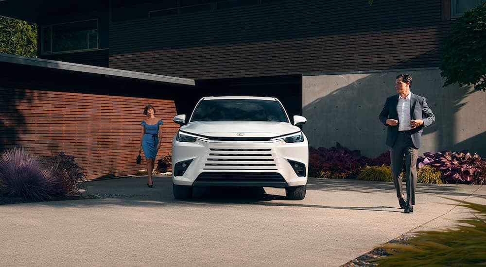 A white 2024 Lexus TX 550h+ is shown parked on a driveway.