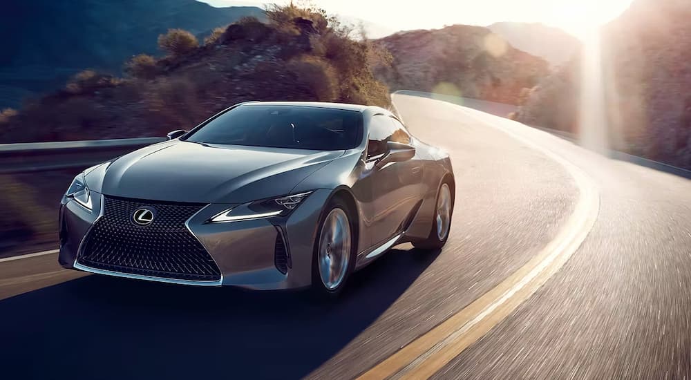 A silver 2023 Lexus LC is shown driving on a winding road.