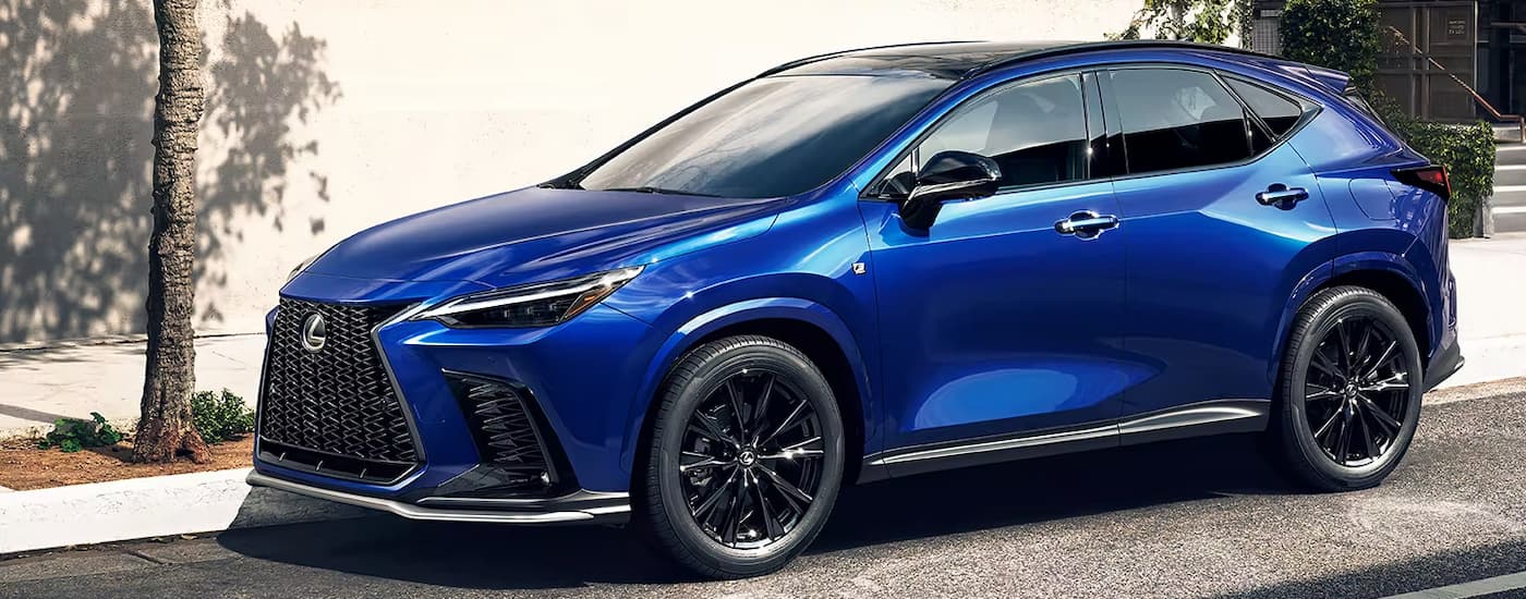 A blue 2023 Lexus NX is shown parked on the side of a city street.