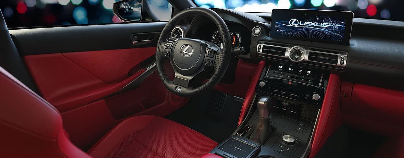 A close up of the red interior of a 2024 Lexus IS shows the center console and dashboard.
