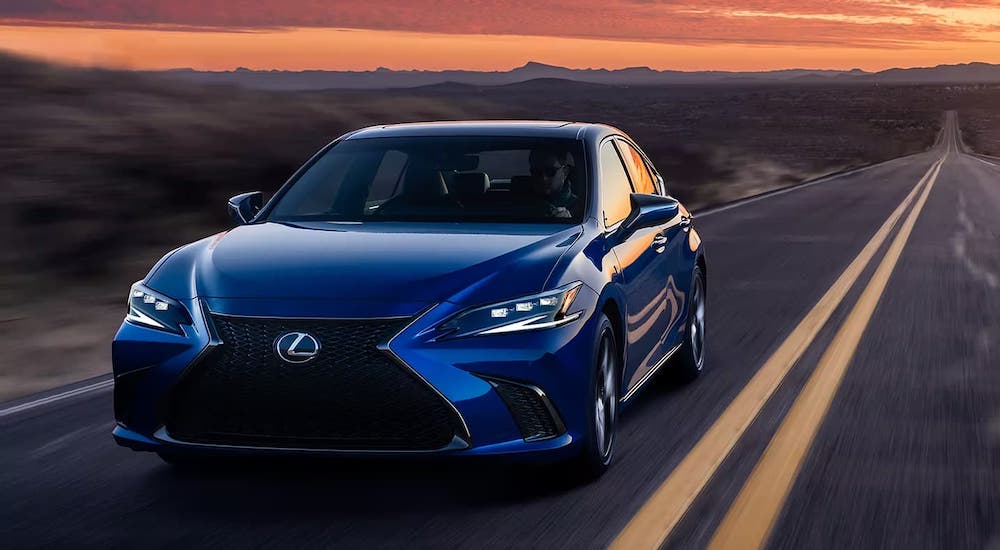 A blue 2024 Lexus ES driving down a desert highway.