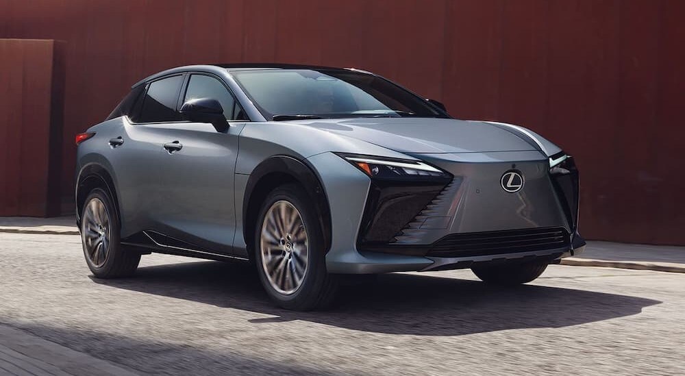 A blue 2024 Lexus RZ is shown driving on a city street.