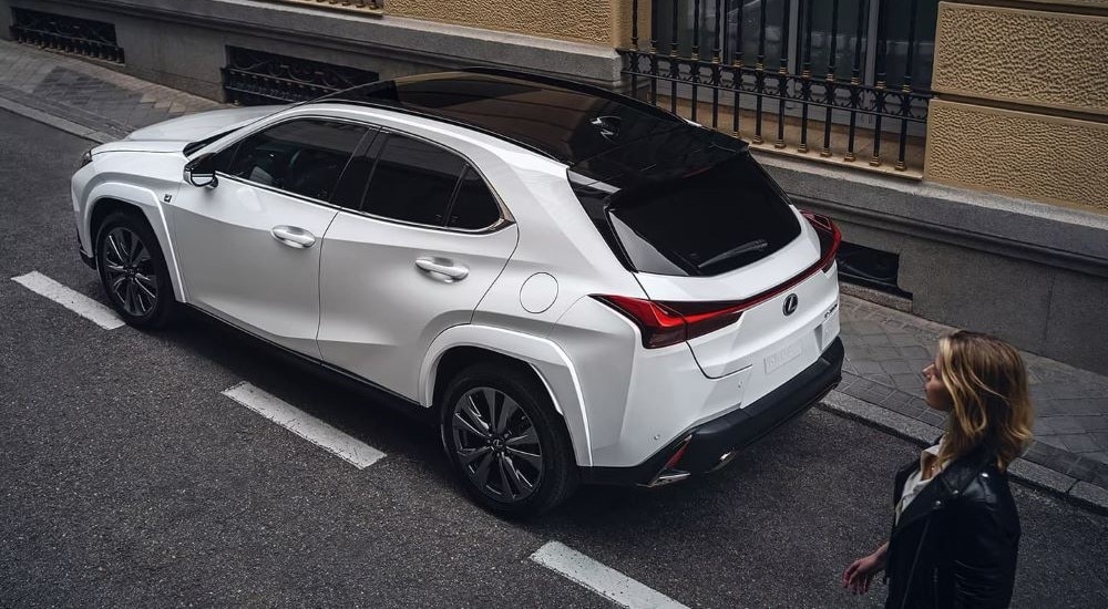 A white 2024 Lexus UX is shown on a city street after leaving a Lexus Dealer in New York City.