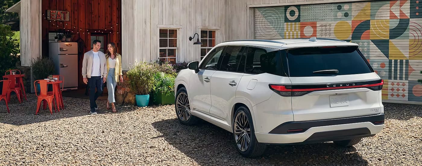 A while 2024 Lexus TX is shown from the rear parked outside of a barn.