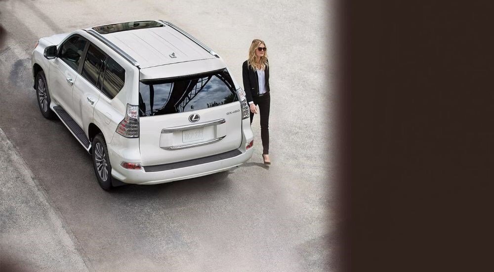 A white 2023 Lexus GX 460 is shown on a city street from a high angle.