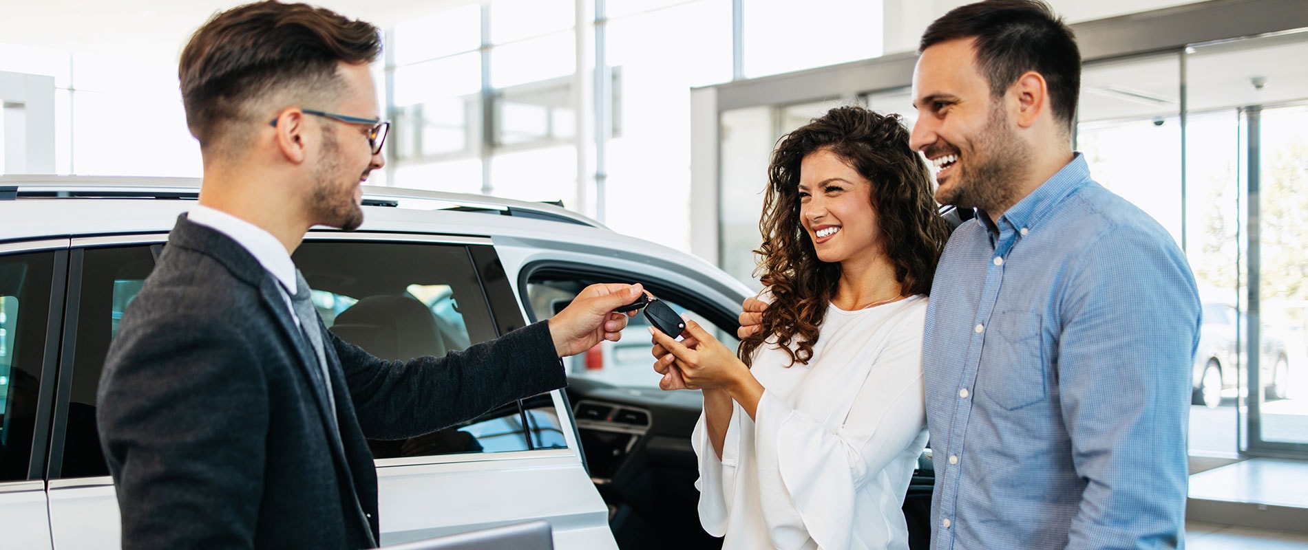Smiling couple receiving the keys to their new Lexus