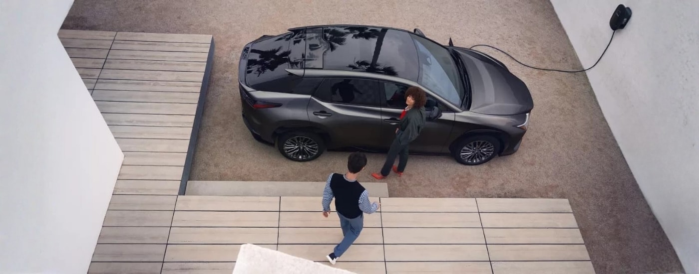 Grey 2023 Lexus RZ charging on a driveway