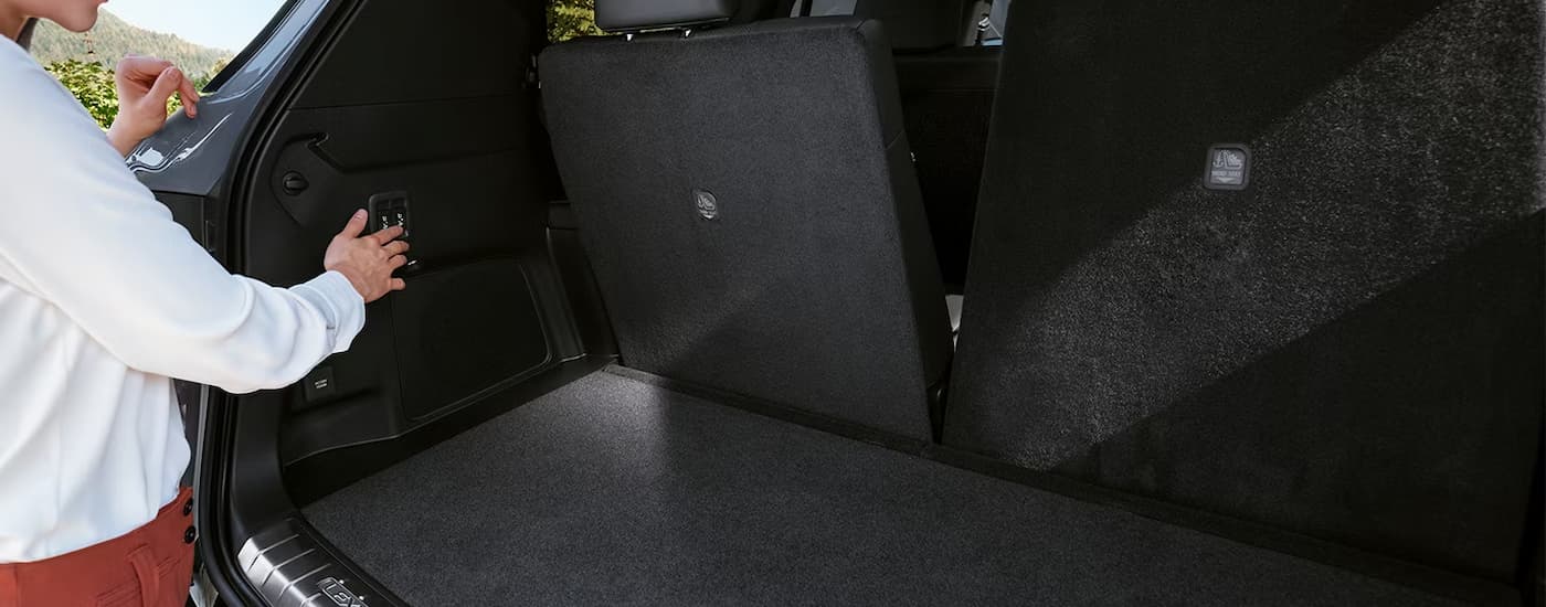 Woman putting the rear seats in a 2026 Lexus TX down