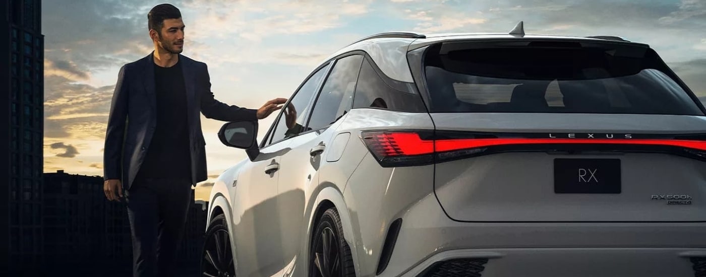 Person admiring a white 2023 used Lexus RX 500h for sale in Peoria