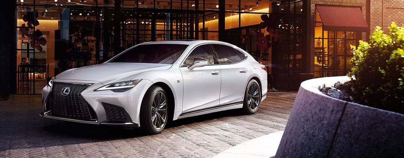 A white  2024 Lexus LS parked near a Lexus dealer.