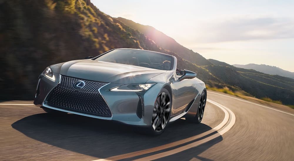 A silver 2024 Lexus LC is shown driving on a highway.