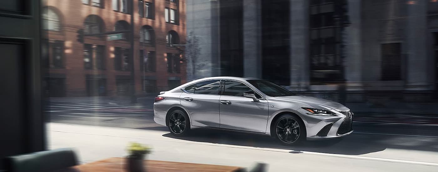 A silver 2024 Lexus ES is shown from the side on a city street.