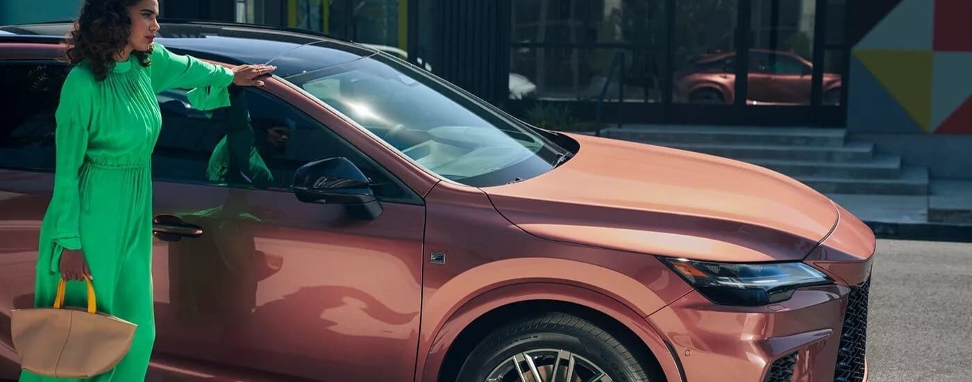 A copper 2023 Lexus RX is shown on a city street after leaving a Lexus dealer.