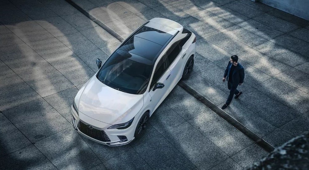 A person is shown walking toward a white 2023 Lexus RX.