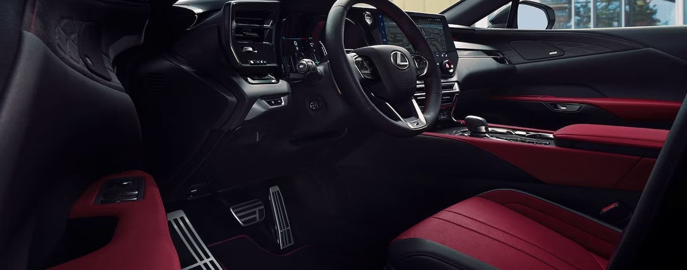 The driver's side of the black and red cockpit of a 2024 Lexus RX.