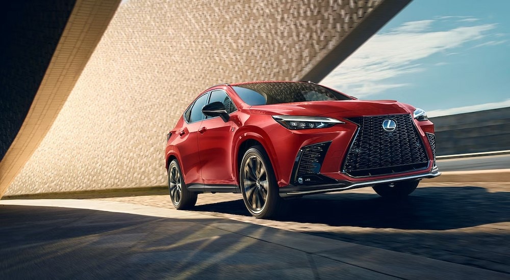 A red 2024 Lexus NX 450h+ F Sport is shown driving to view a Lexuz NX for sale in Long Island City.