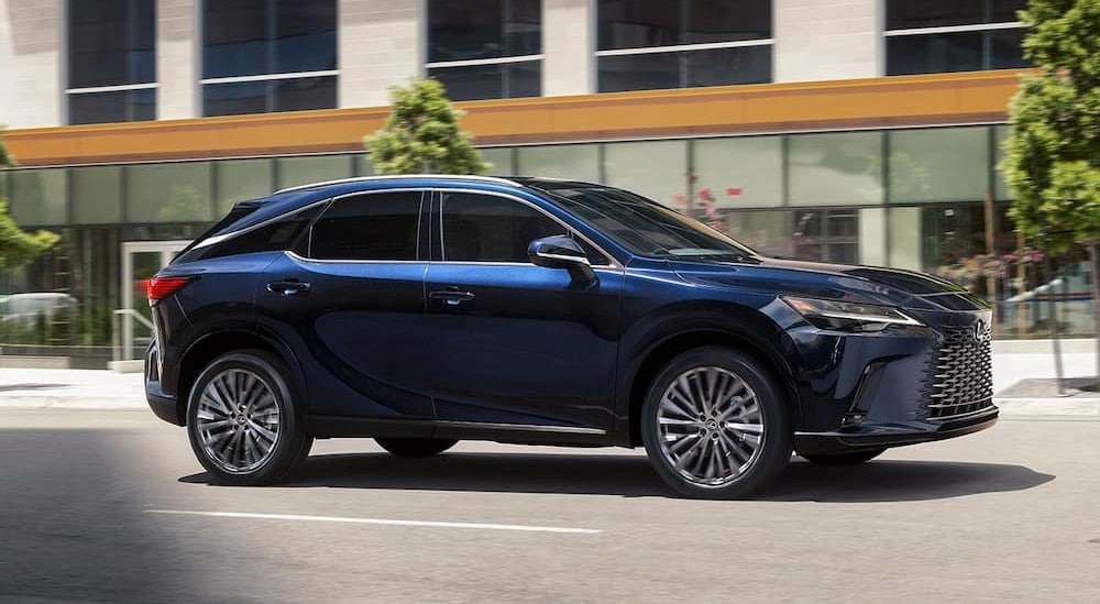 A blue 2024 Lexus RX for sale in Long Island City is shown driving on a highway.