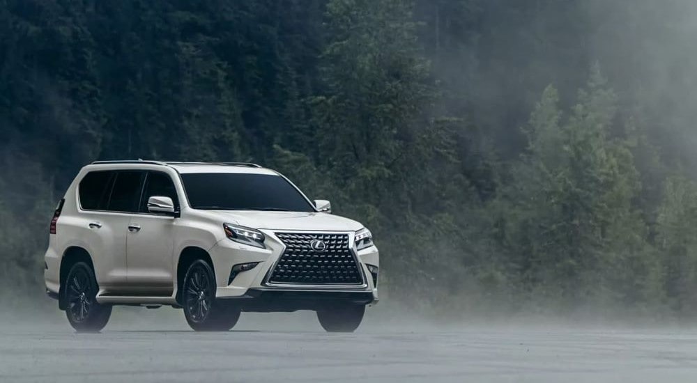 A white 2023 Lexus GX is shown parked off-road on a foggy day.